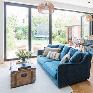 blue sofa with cushions in open plan kitchen diner