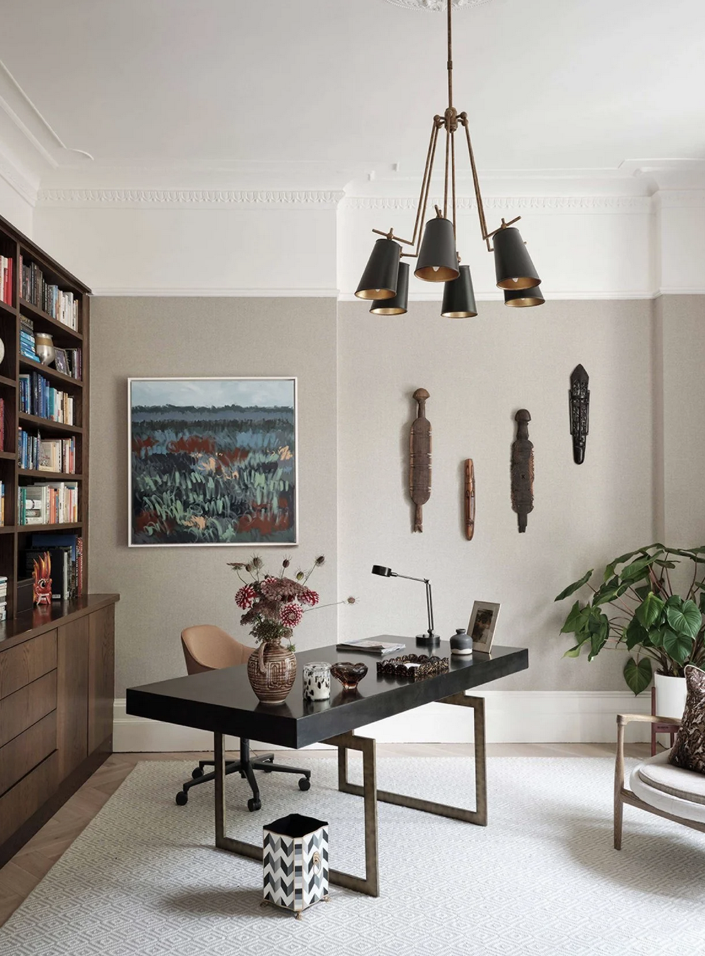 A contemporary home office with artwork, ceramics, and decorative pieces.