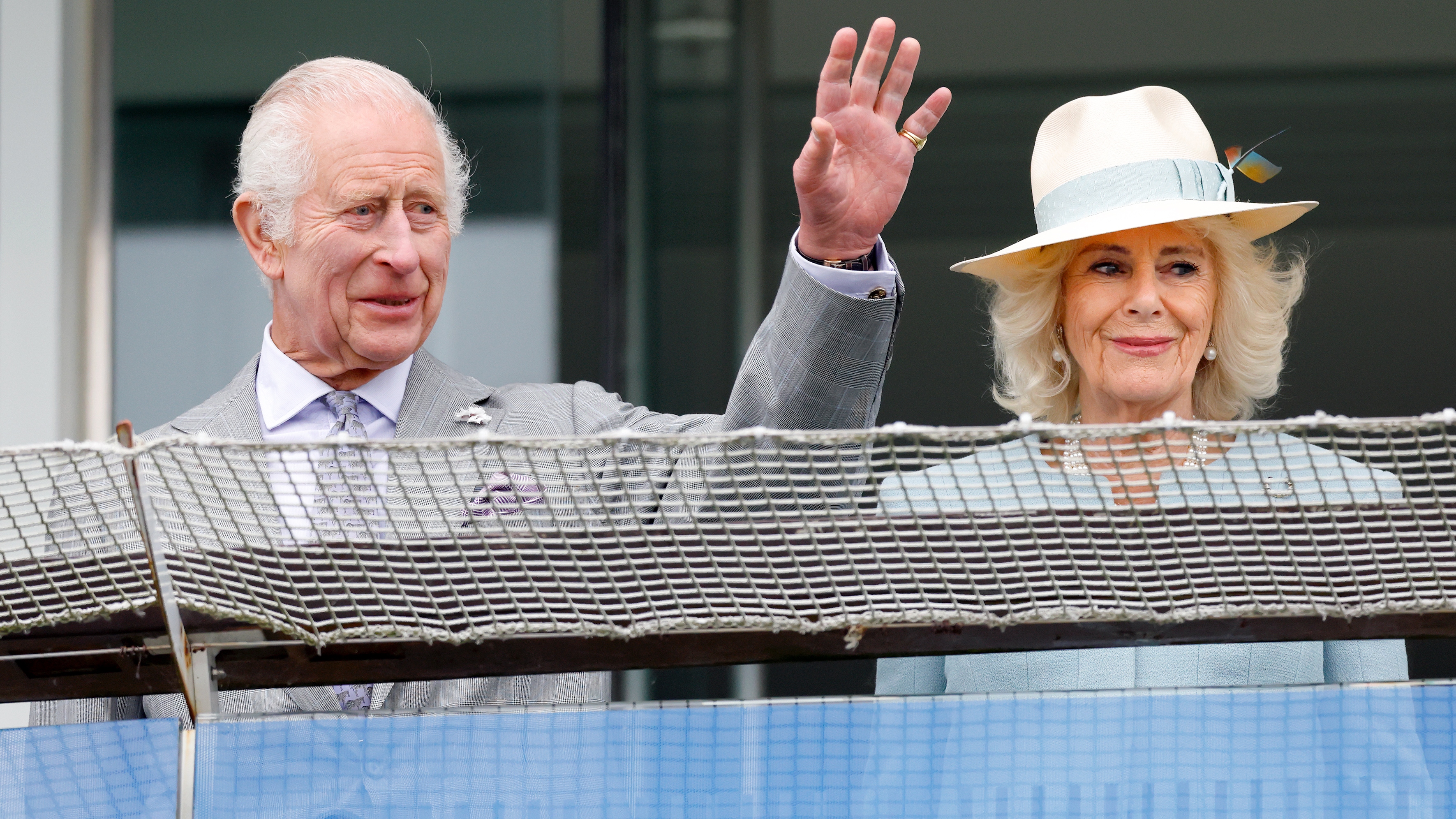King Charles waves and Queen Camilla watches the racing as they attend 'Ladies Day' of the Betfred Derby Festival 2024 at Epsom Downs Racecourse on May 31, 2024