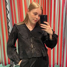 Woman in dressing room wears black lace shirt