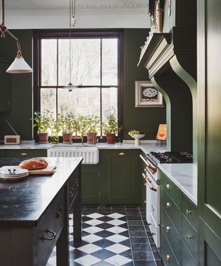 Green kitchen with large window and checkerboard flooring