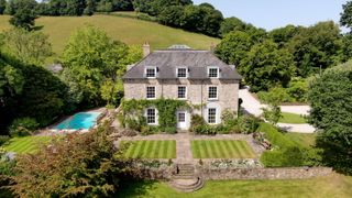 An exterior view of the property with lawned garden and ivy growing up the frontage