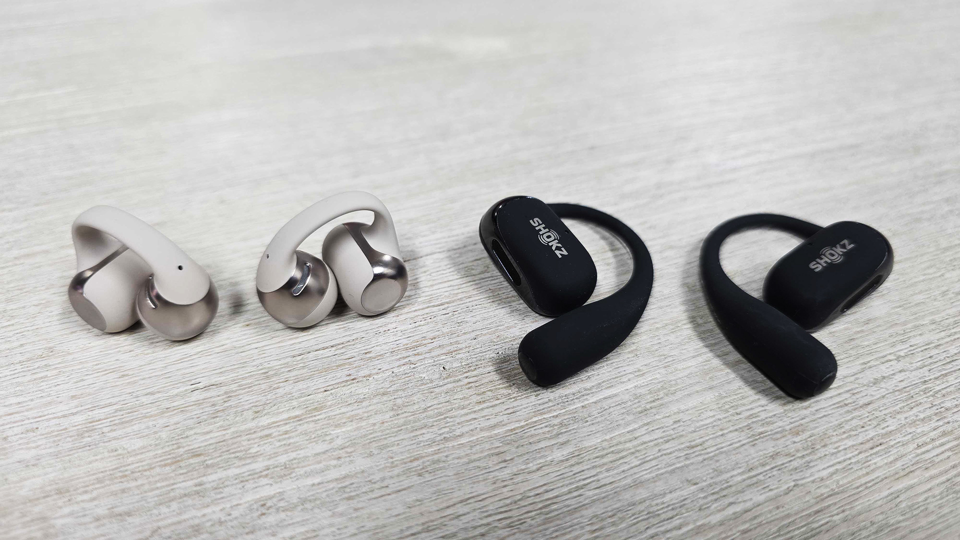 Shokz OpenDots One and Shokz Openfit 2 buds placed next to each other on table