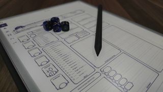 A DnD character sheet displayed on a reMarkable Paper Pro, with a set of dice on top