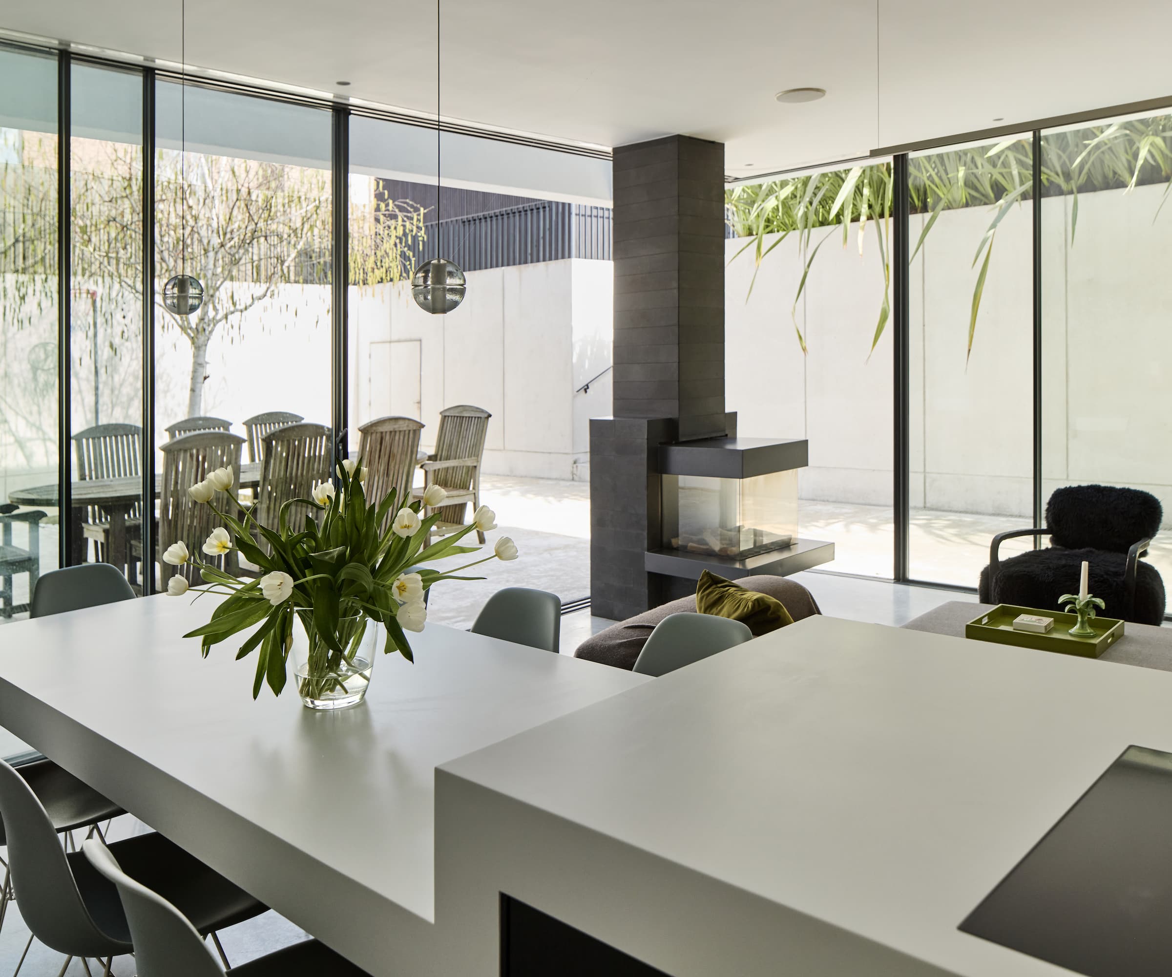 A kitchen dining area with a layered kitchen island with a grey worktop and a black woodburner