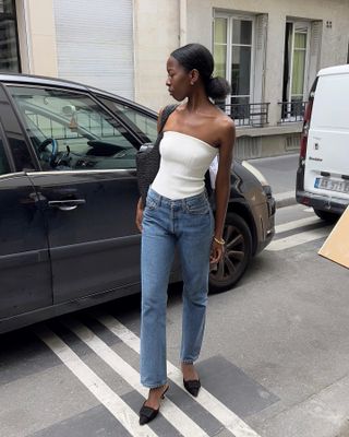 Woman in strapless top and jeans.