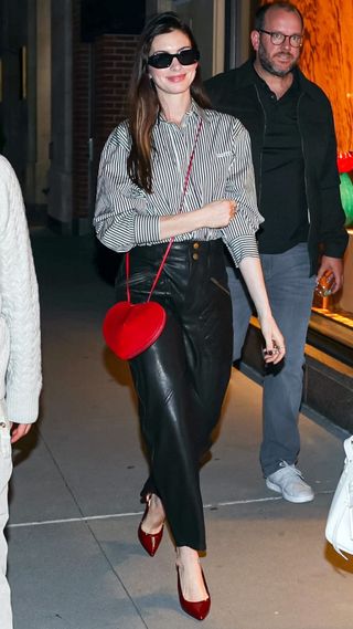 Anne Hathaway wearing leather trousers and burgundy slingback heels