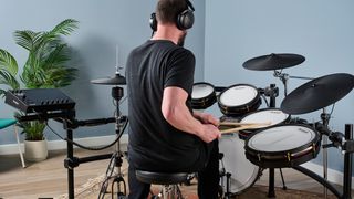 Man playing Alesis Strata Prime electronic drum set