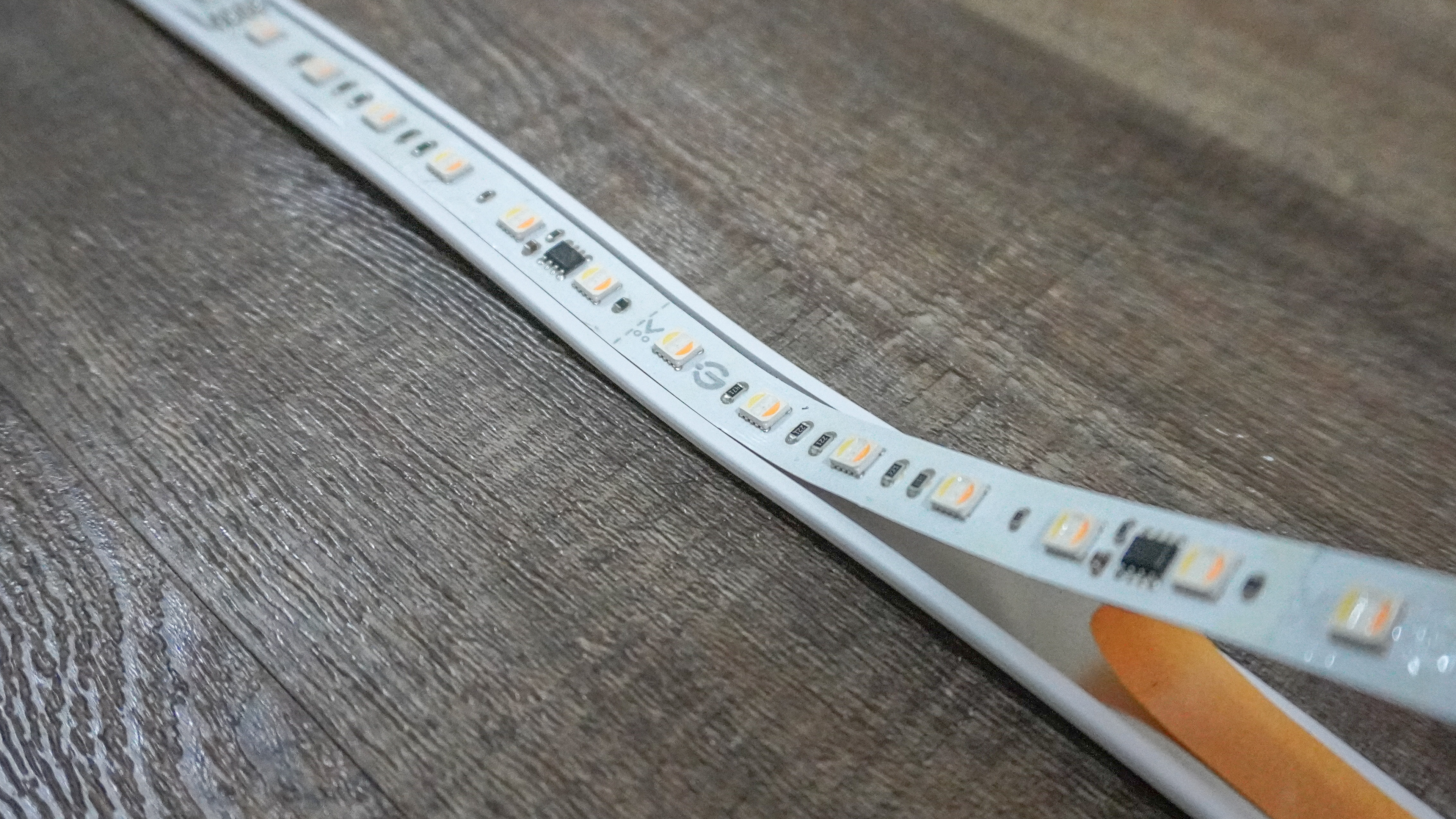 Sticking the lightstrip to the metal housing while installing the Govee Strip Light with Skyline Kit