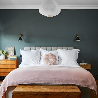 bedroom with grey wall wooden bed and white lamp