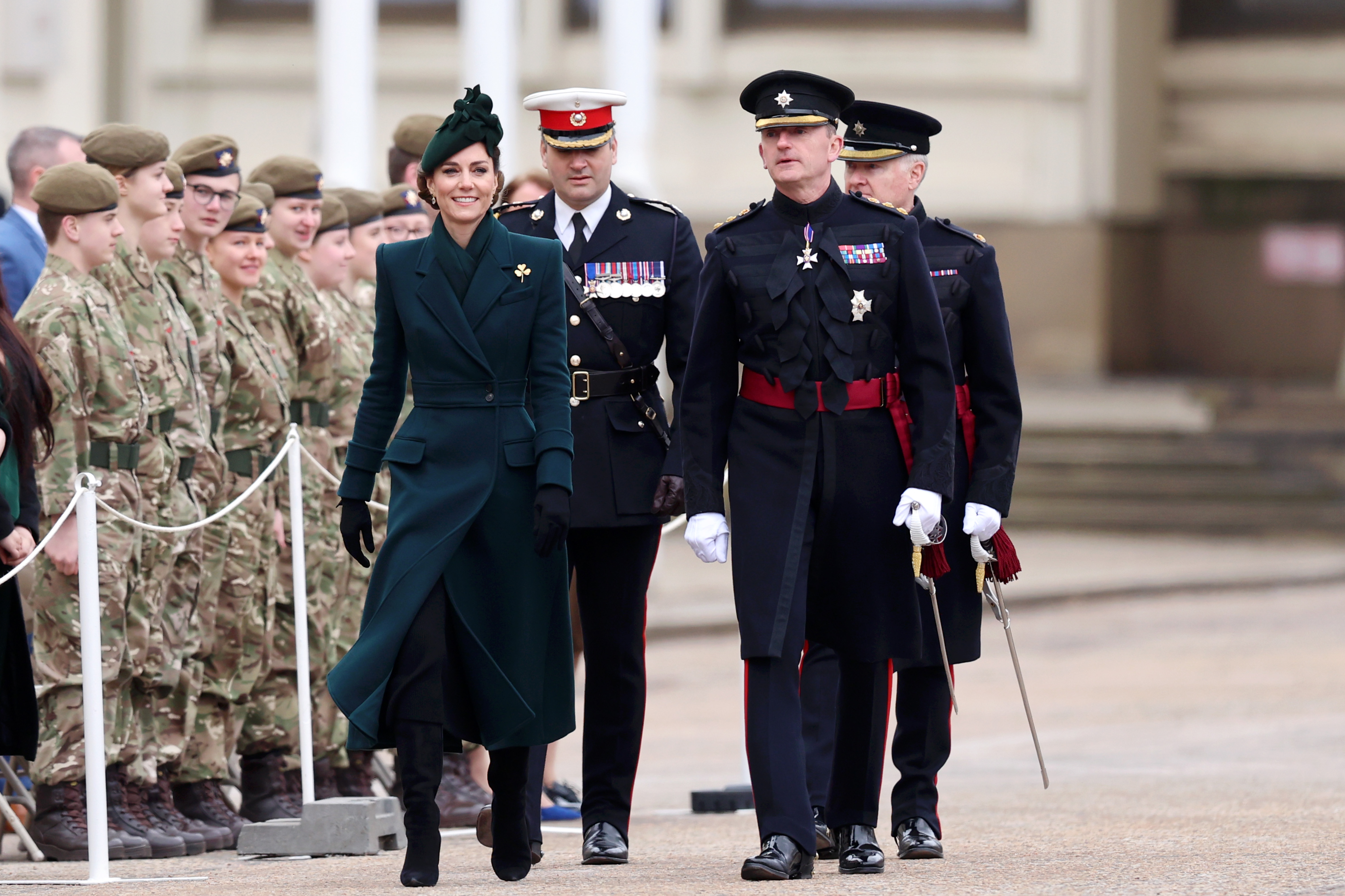 Kate Middleton wearing a green coat and walking alongside soldiers on St Patrick's Day 2025