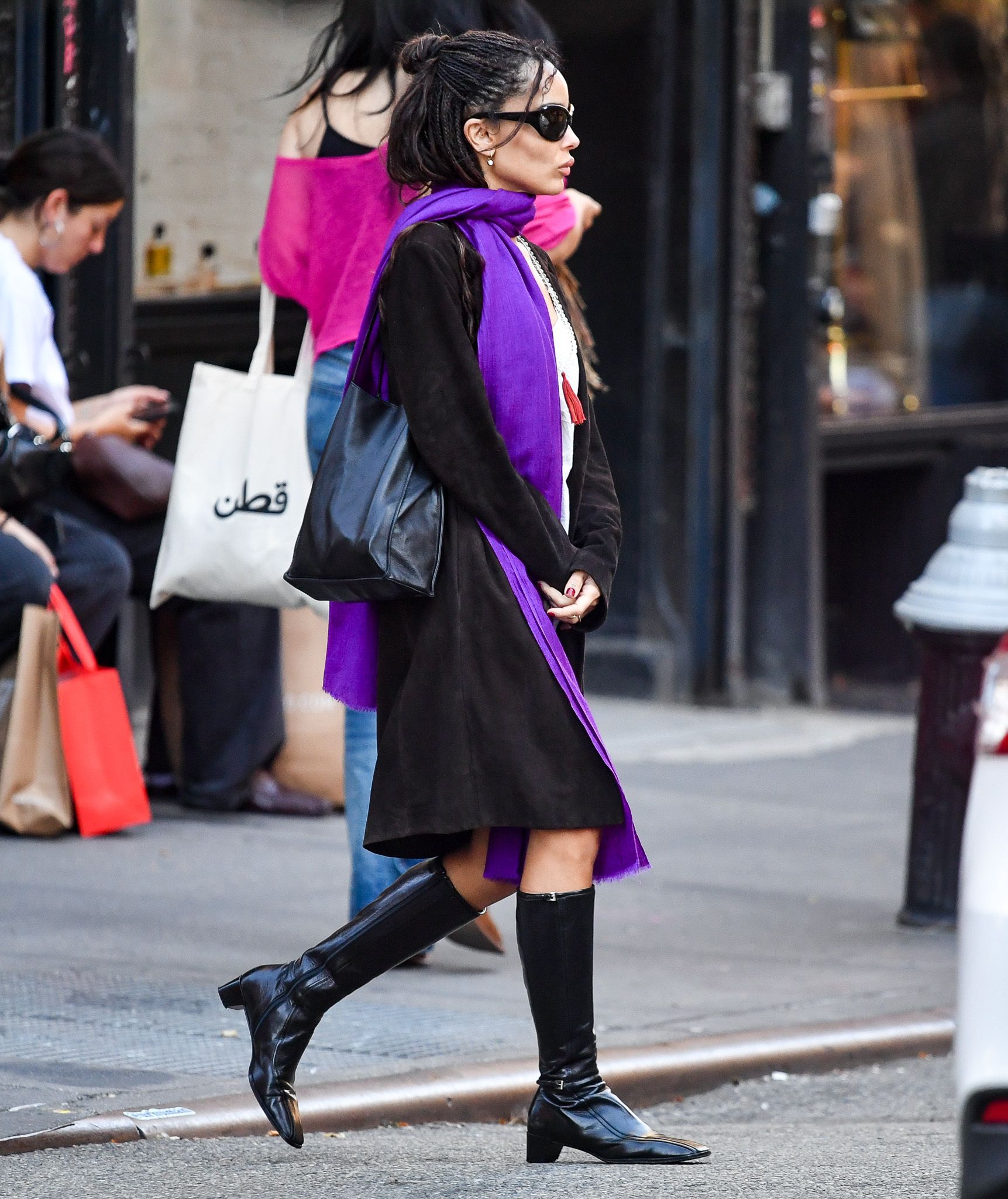 Zoe Kravitz is spotted stepping out in New York City. The 37-year-old American actress wore a white top under a black coat paired with a vibrant purple scarf and black patent leather boots.