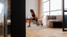 Young woman exercise in living room uwinf dumbbells