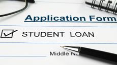 A student loan application with a pen lying across it.