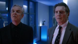 Danny Huston and Liam Neeson looking together at something off camera in The Naked Gun 2025.