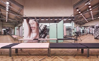 Fashion runway with parquet flooring, pink and black padded benches, and mirrors