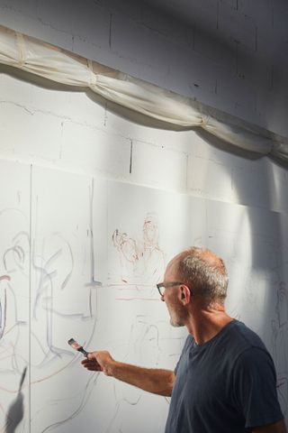An artist is painting on the wall