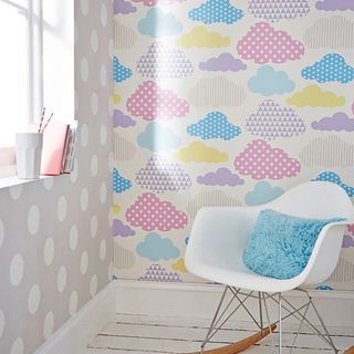 Children's bedroom with bright cloud design wallpaper and designer chair