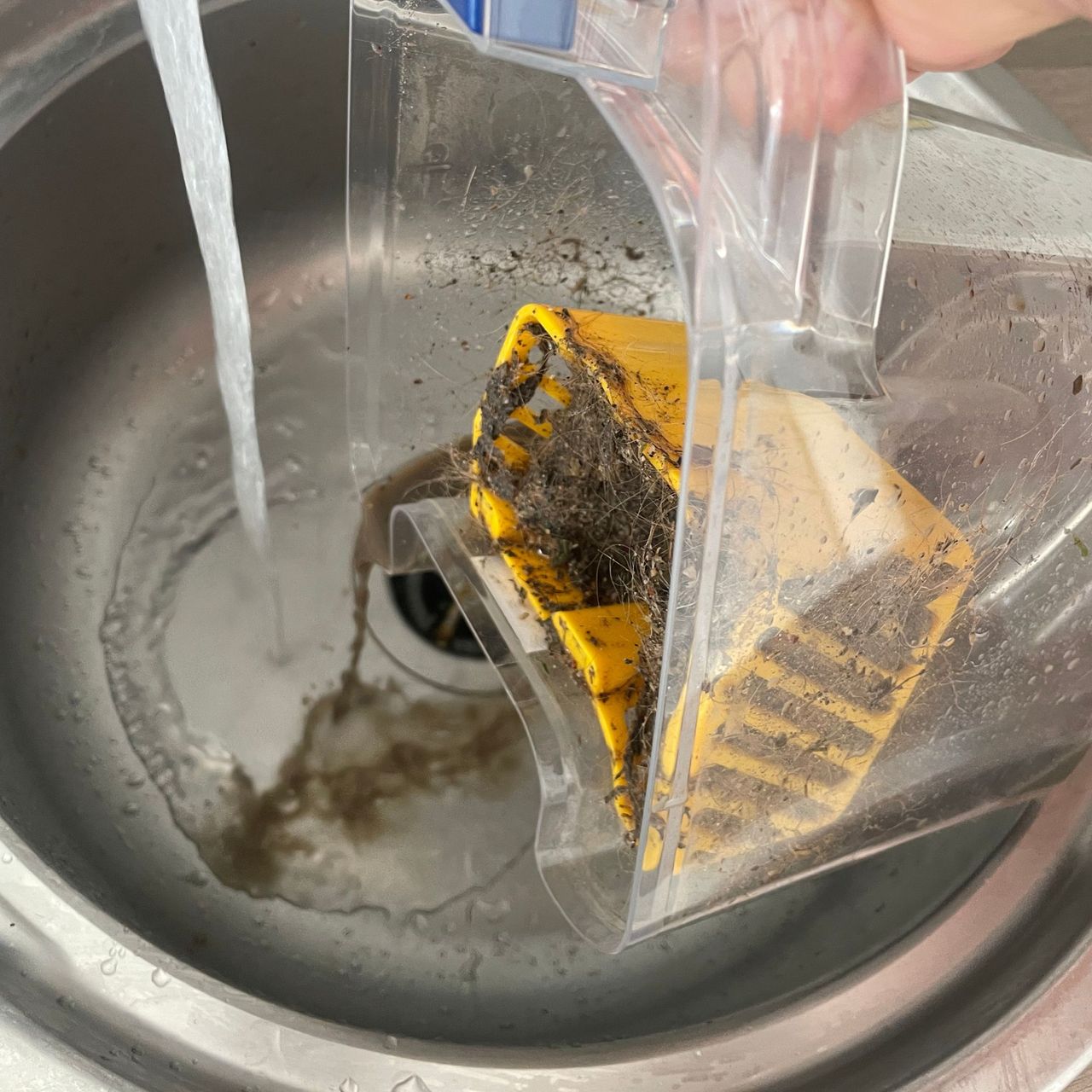 Pouring the dirty water tank of the Shark CarpetXpert HairPro Pet Deep Carpet Cleaner with Spot Cleaner EX250UK down a sink