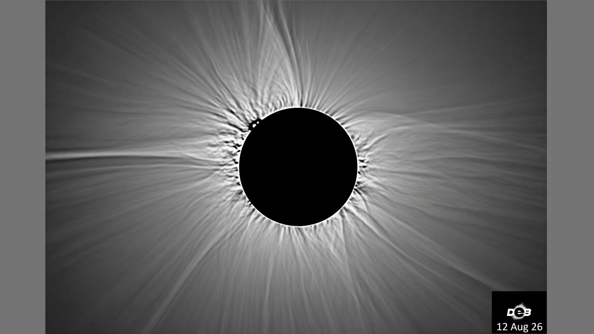 An eclipsed sun is shown with the structure of its atmosphere surrounding the silhouette of the moon