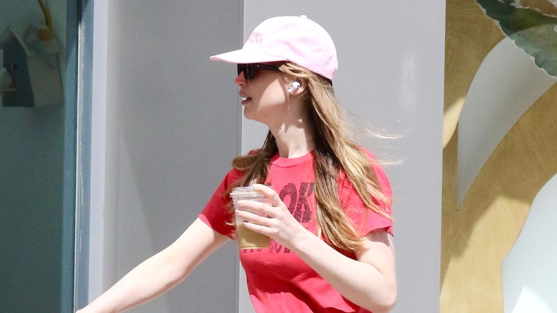 An image of Jennifer Lawrence wearing a red t-shirt with pink pants and slide sandals.
