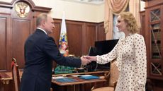 Maria Lvova-Belova and Vladimir Putin shaking hands in the Kremlin