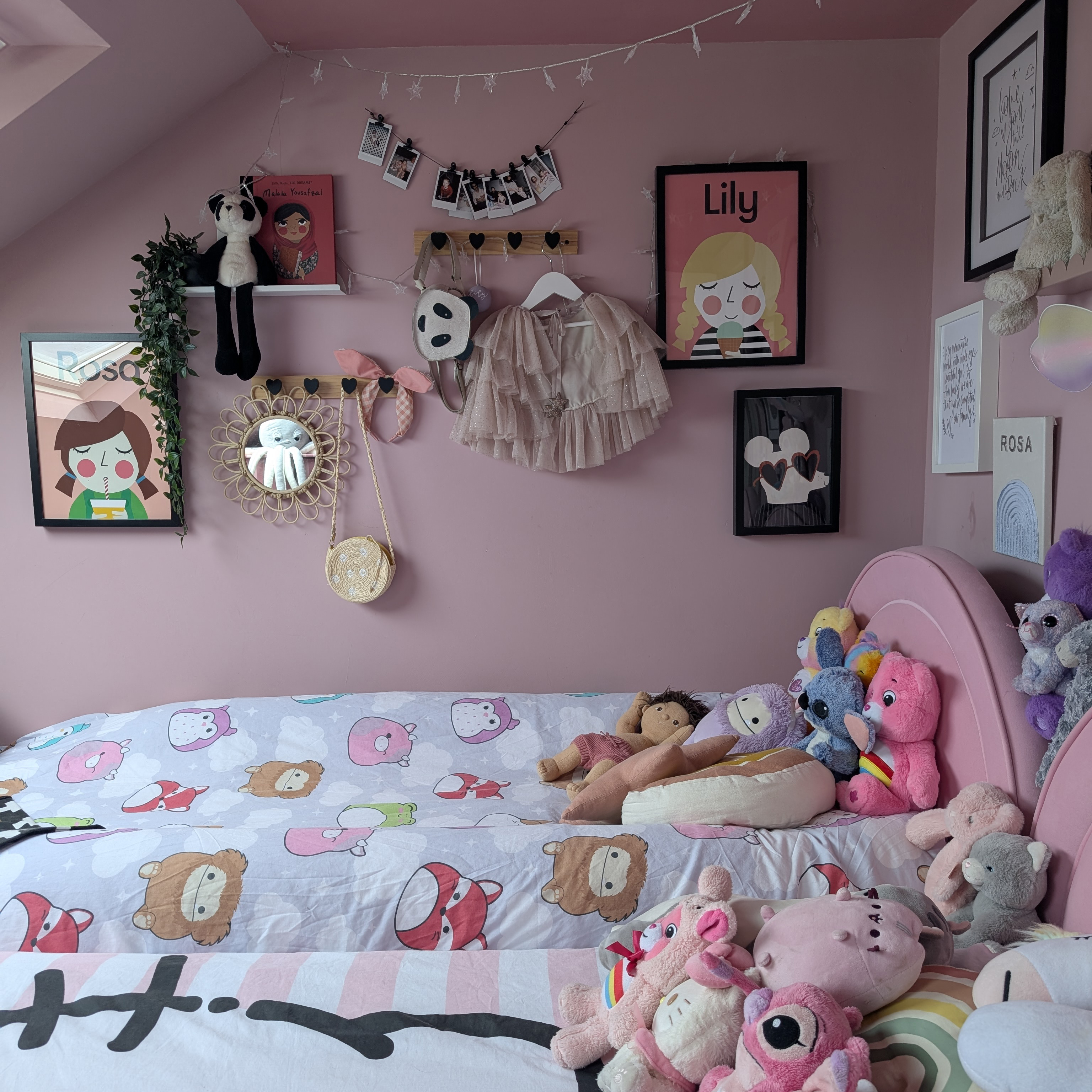 pin girl&#039;s bedroom with teddies on the bed and framed prints on the wall