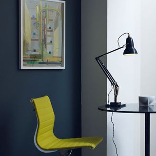 room with grey wall and painting with anglepoise lamp and yellow chair