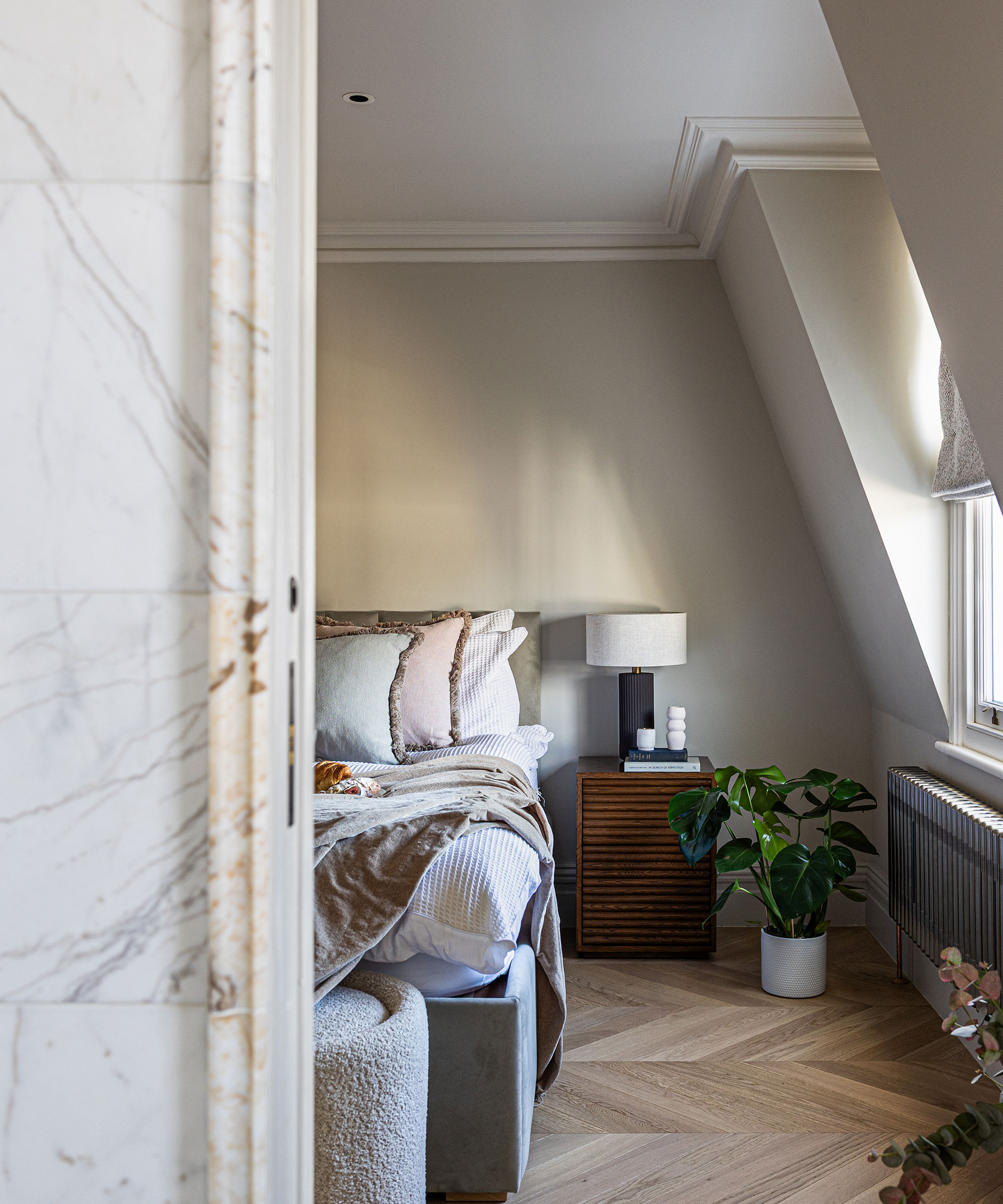 master bedroom in loft space with wooden herringbone flooring