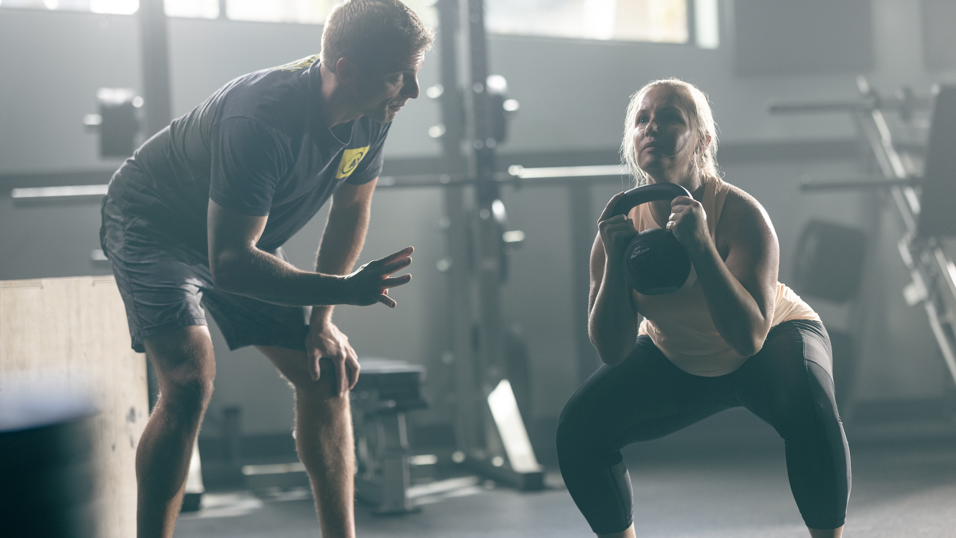 Woman lifting weights with a personal trainer