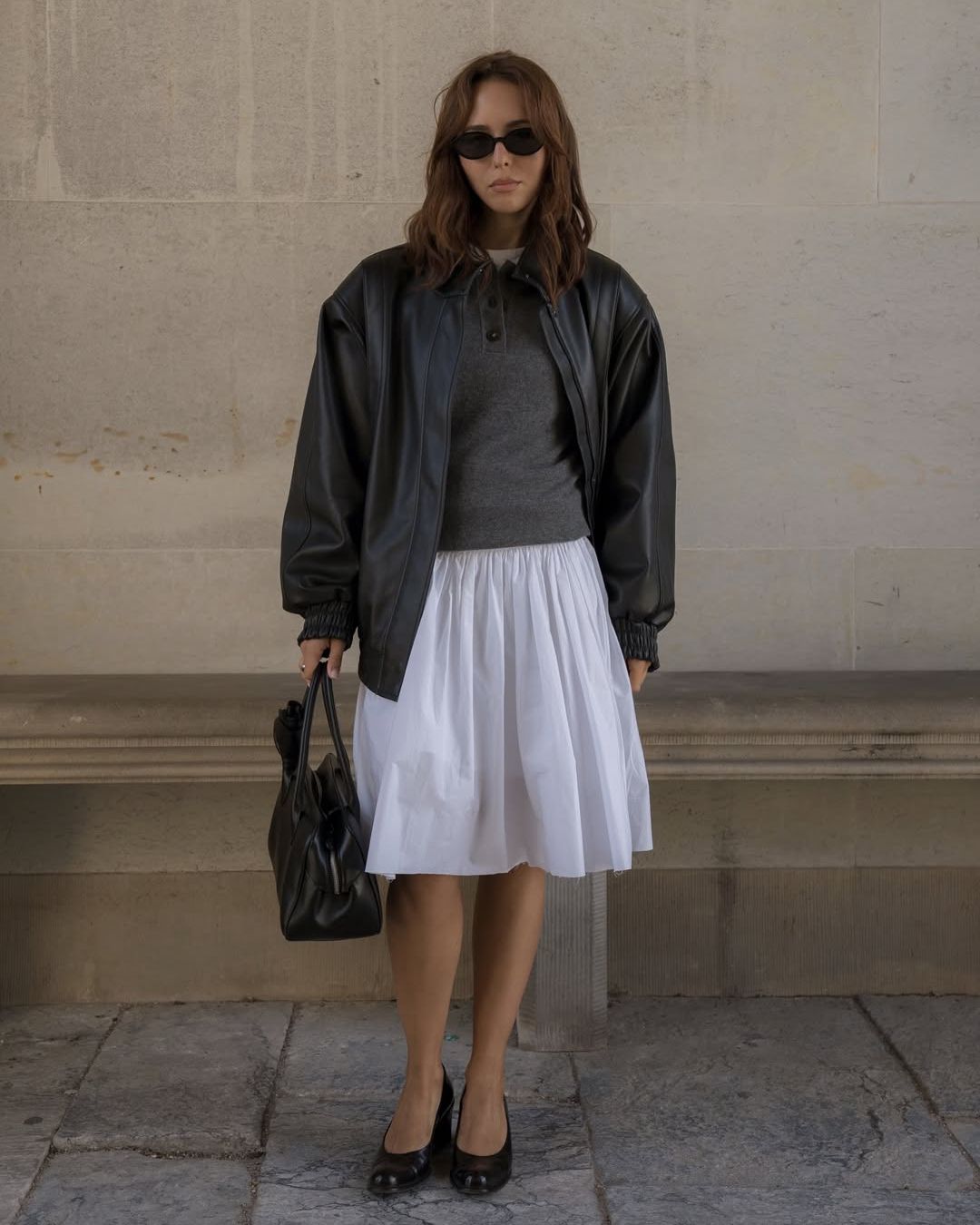 debora rosa wears a grey jumper and white skirt