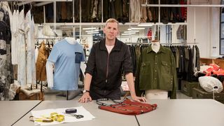 Man stood at desk in fashion workshop