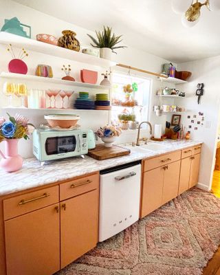 Brightly colored kitchen units with decorative shelving complete with eclectic trinkets