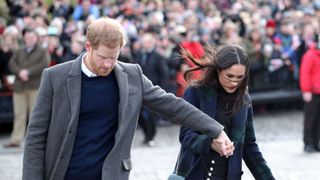 Britain's Prince Harry and his fiancée, US actress Meghan Markle walk into Edinburgh Castle, during a visit to Scotland on February 13, 2018. / AFP PHOTO / POOL / Jane Barlow (Photo credit should read JANE BARLOW/AFP via Getty Images)