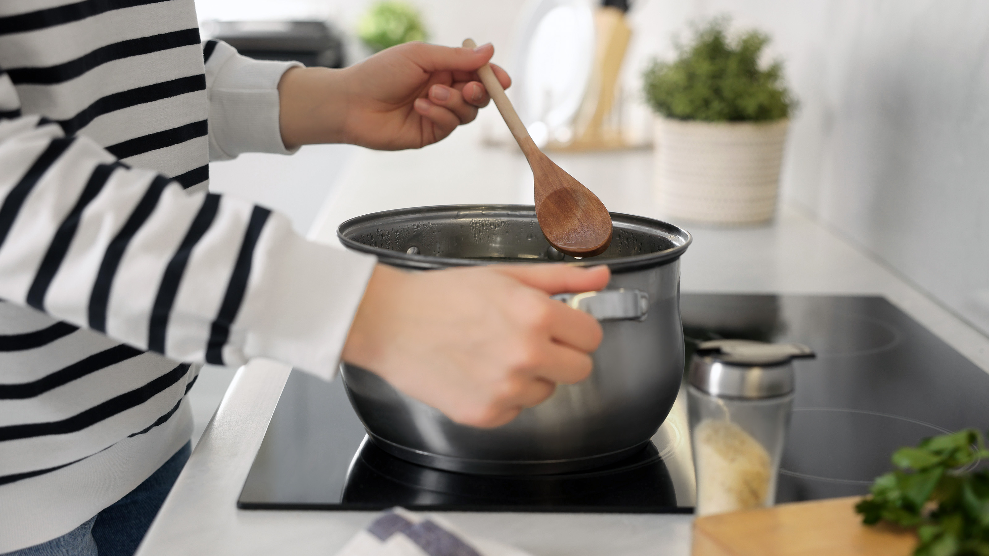 wooden spoon being used to stir a saucepan