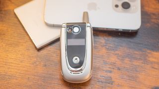 Motorola V600 flip phone on top of iPhone 14 Pro and Galaxy S23 Ultra