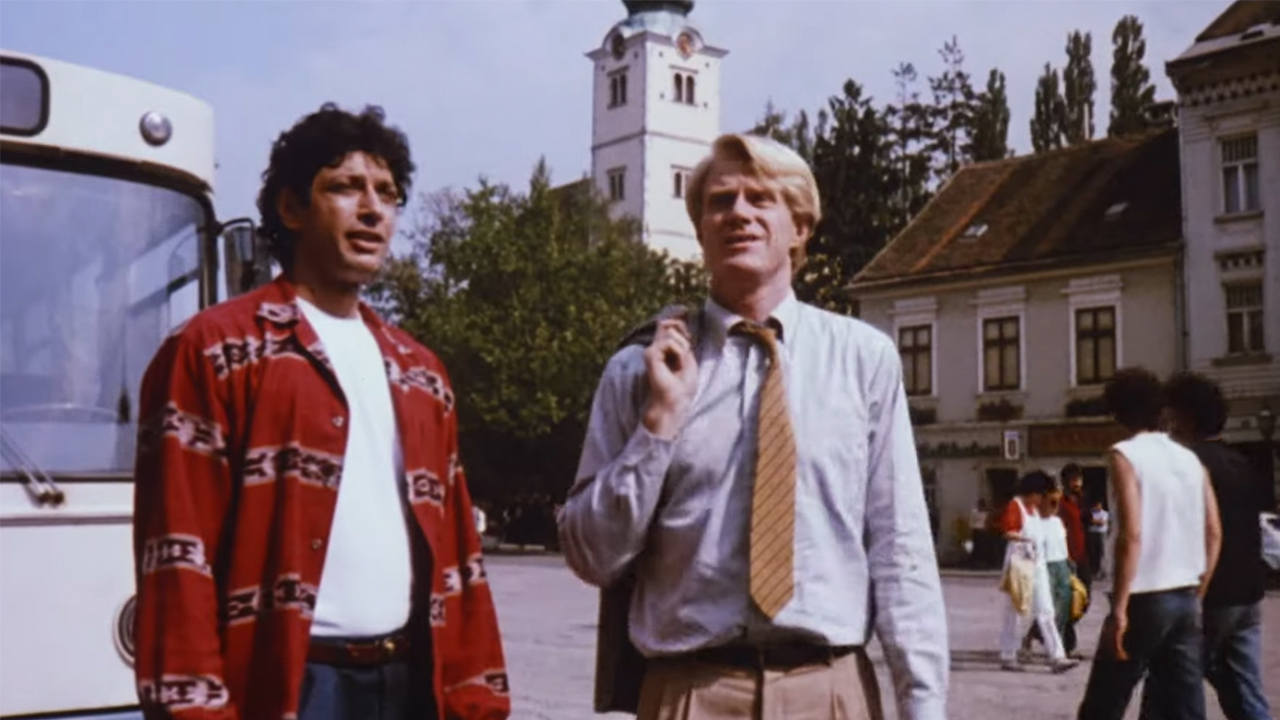 Jeff Goldblum and Ed Begley, Jr standing in front of a bus in an European town