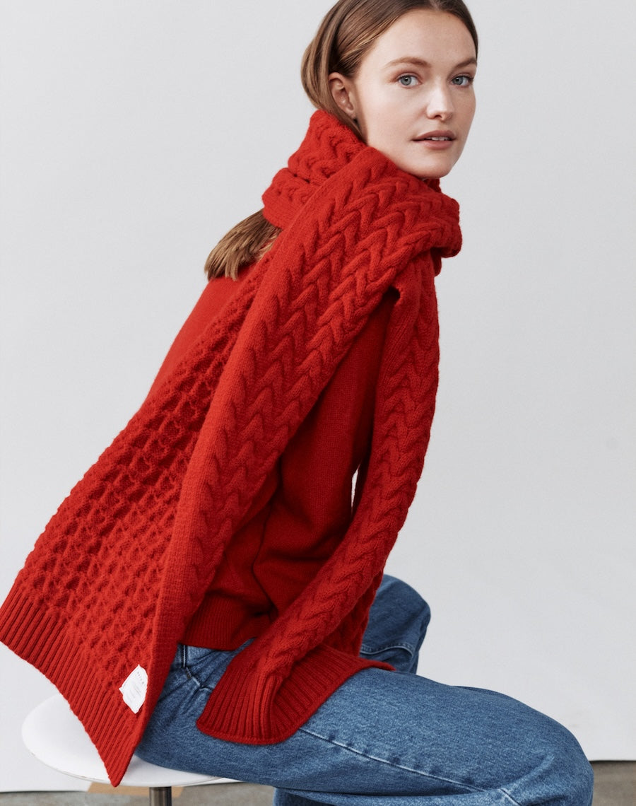 a model wearing a red cable-knit scarf from navygrey