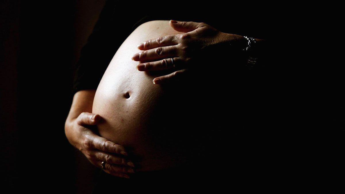 A mother-to-be holding her stomach 