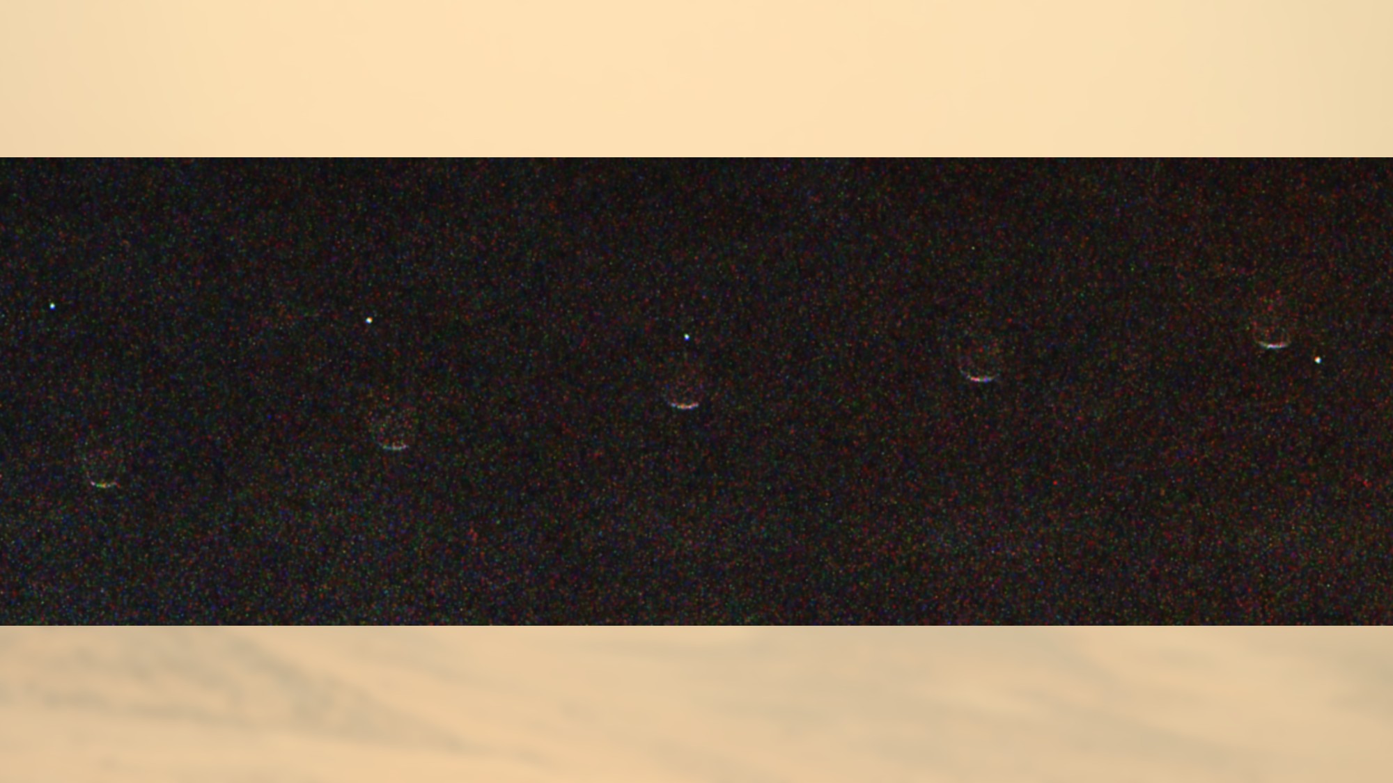 a dot of light disappears behind a crescent of light on a grey background