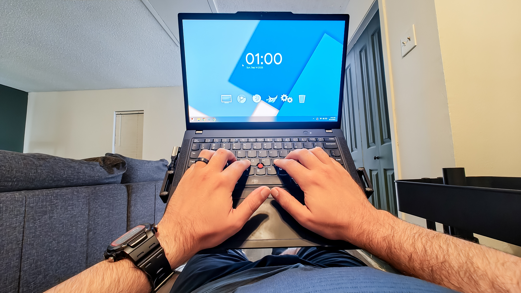 A close-up shot of a person working on their laptop while reclining in an office chair at a DIY rollable workstation
