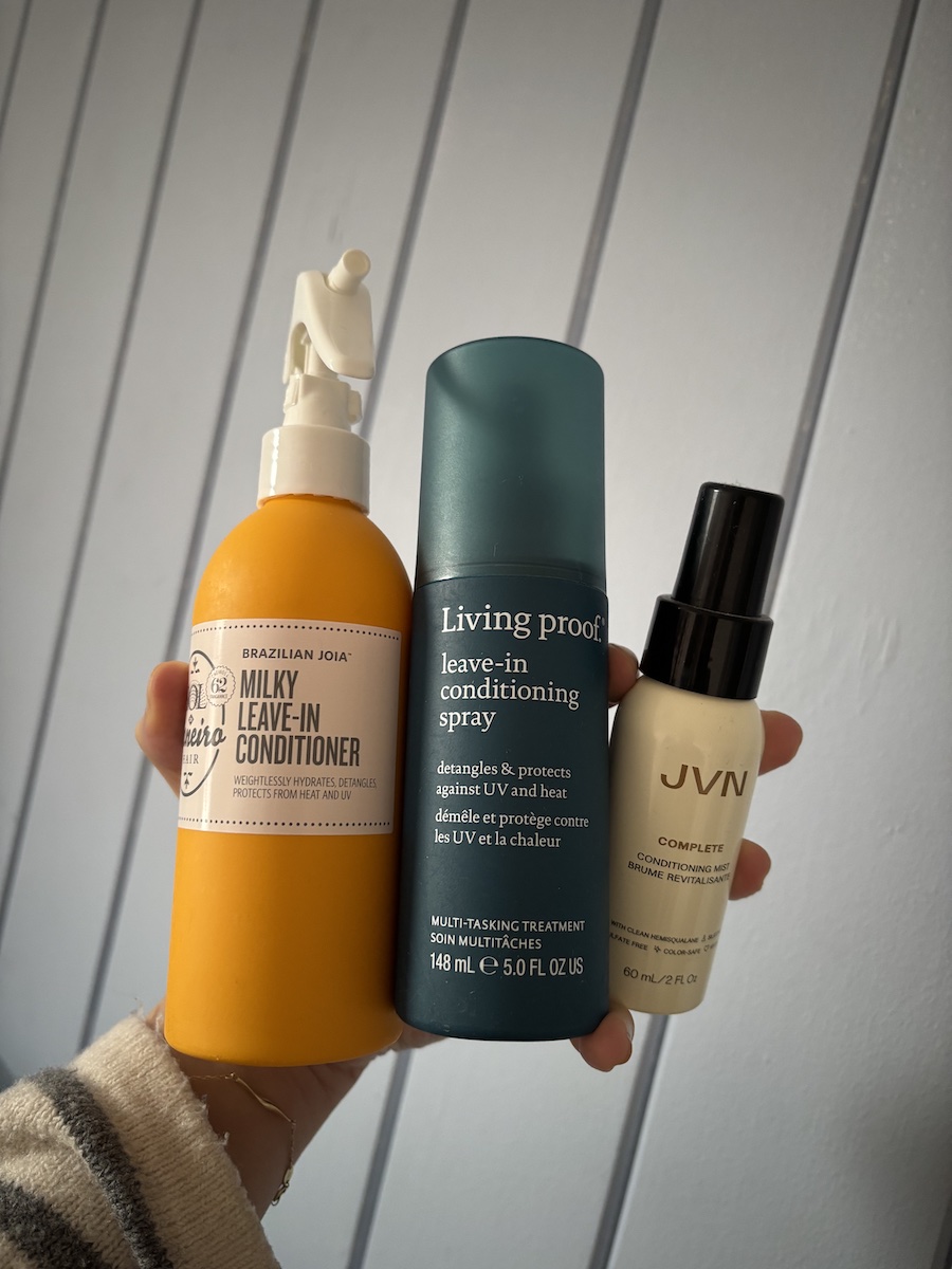 Mica Ricketts holding selection of best detangling sprays