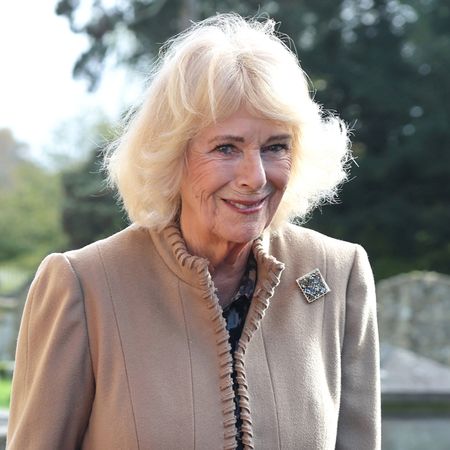Queen Camilla wears a beige coat with a brooch