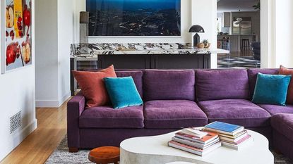 A purple sofa with red and blue cushions