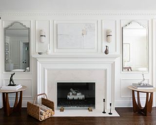 Living room fireplace with objects on mantel, artwork above and mirrors to either side