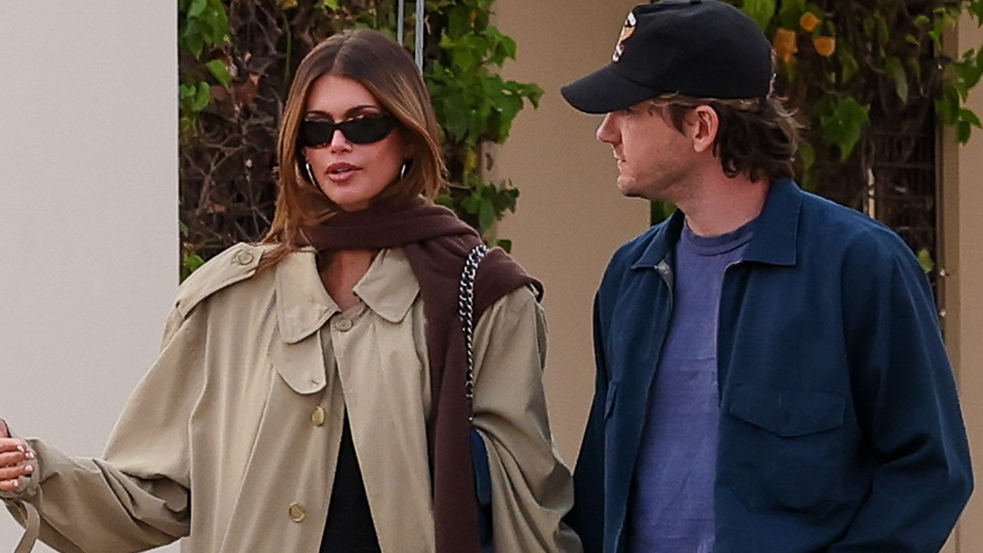 Kaia Gerber's French girl outfit includes a little black dress, a Chanel bag, a timeless trench coat, and ballet flats