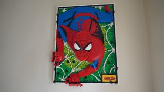 The completed Lego Marvel Amazing Spider-Man set hung up on a cream wall