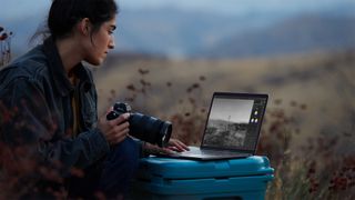Apple M1 MacBook Pro 13-inch review: image shows female photographer using Apple M1 MacBook Pro 13-inch outdoors
