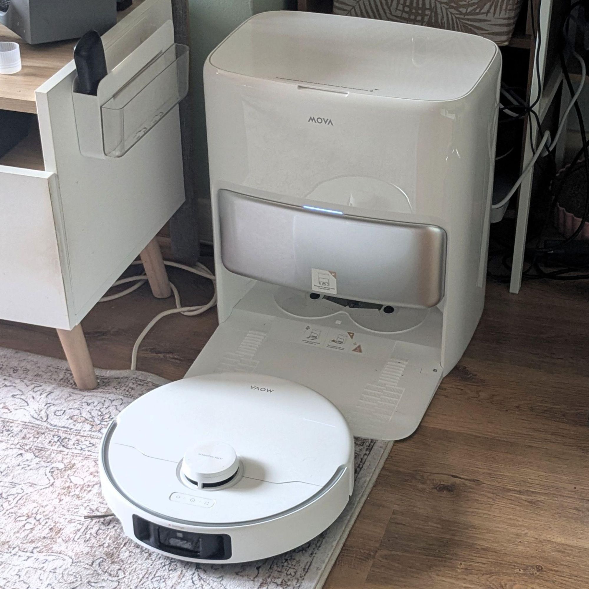 MOVA P50 Pro Ultra Robot Vacuum and docking station located next to a TV unit in a living room