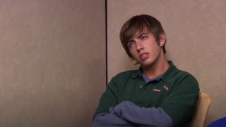 A pizza delivery boy (Kevin McHale) held hostage in the conference room
